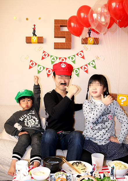 マリオの帽子をかぶったおじさんと子供たちの画像