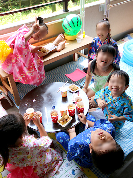 ベランダで輪になってたこ焼きを食べる子供たち　夏祭り・縁日テーマのパーティー演出　お誕生会　キッズパーティー