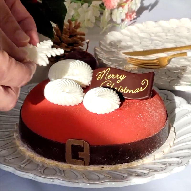 可愛いサンタ風クリスマスケーキ「アグネス・ペストリーブティック／ノエル・ショコラ・ルージュ」チョコレートを自分でトッピングするシーン