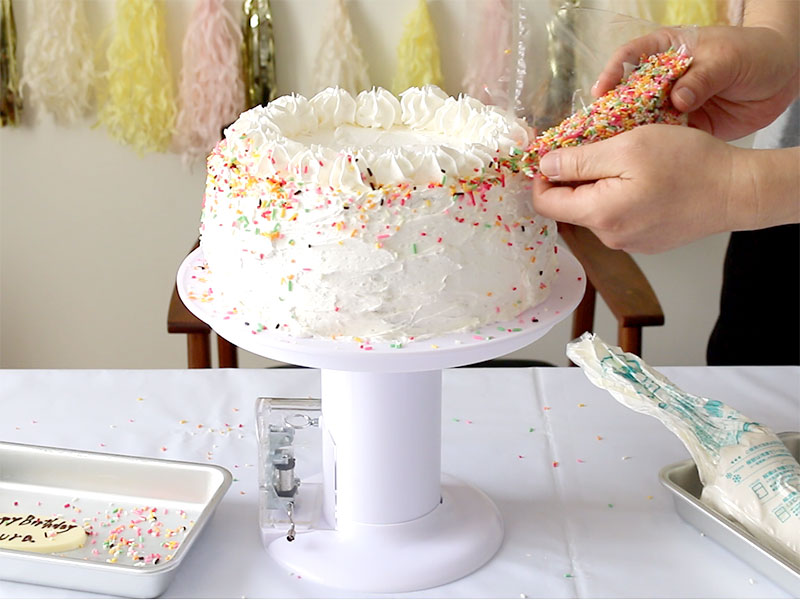 ケーキをデコレーションする五色スプレーをふりかける