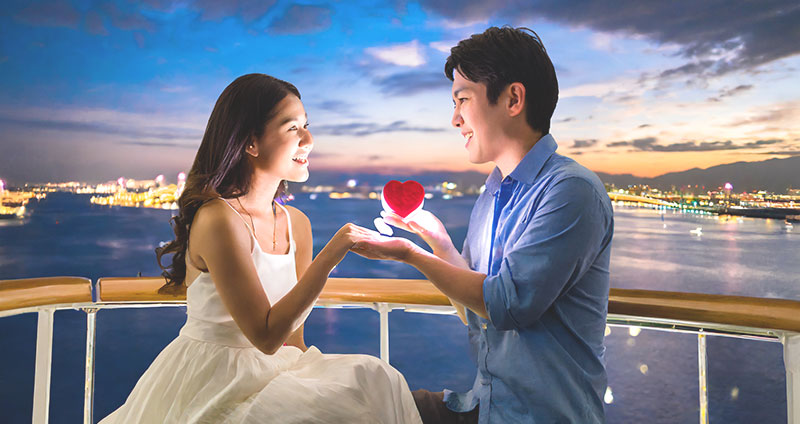 クルーズ船の甲板でプロポーズをするカップル