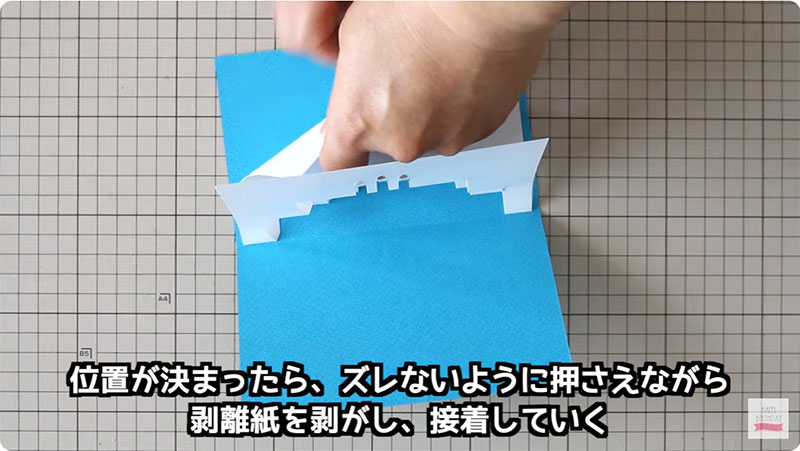 位置が決まったら、ズレがないように押さえながら剥離紙を剥がし、接着していく